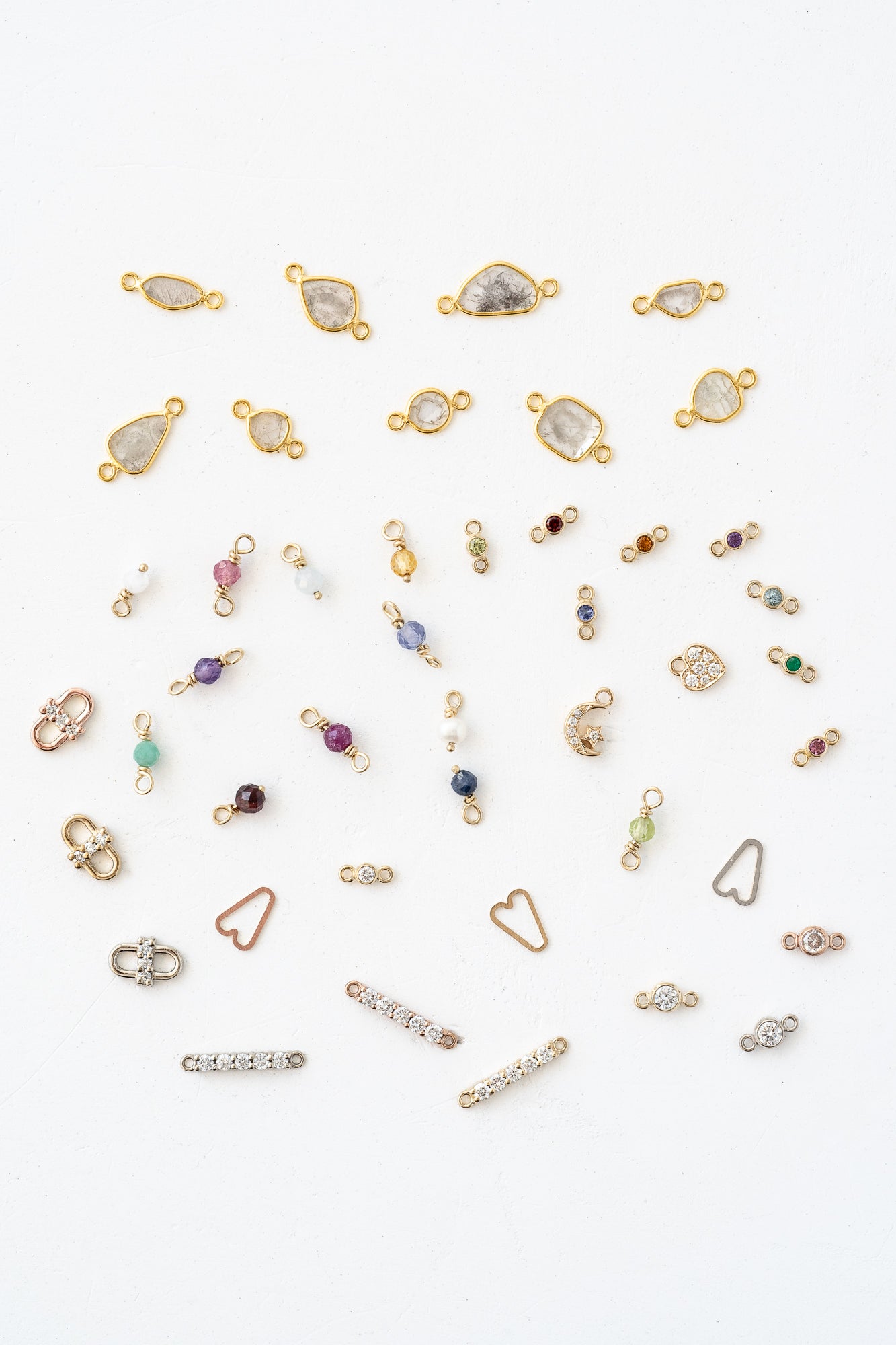 Various gold and silver jewelry, including charms, displayed in an assortment of styles and designs.