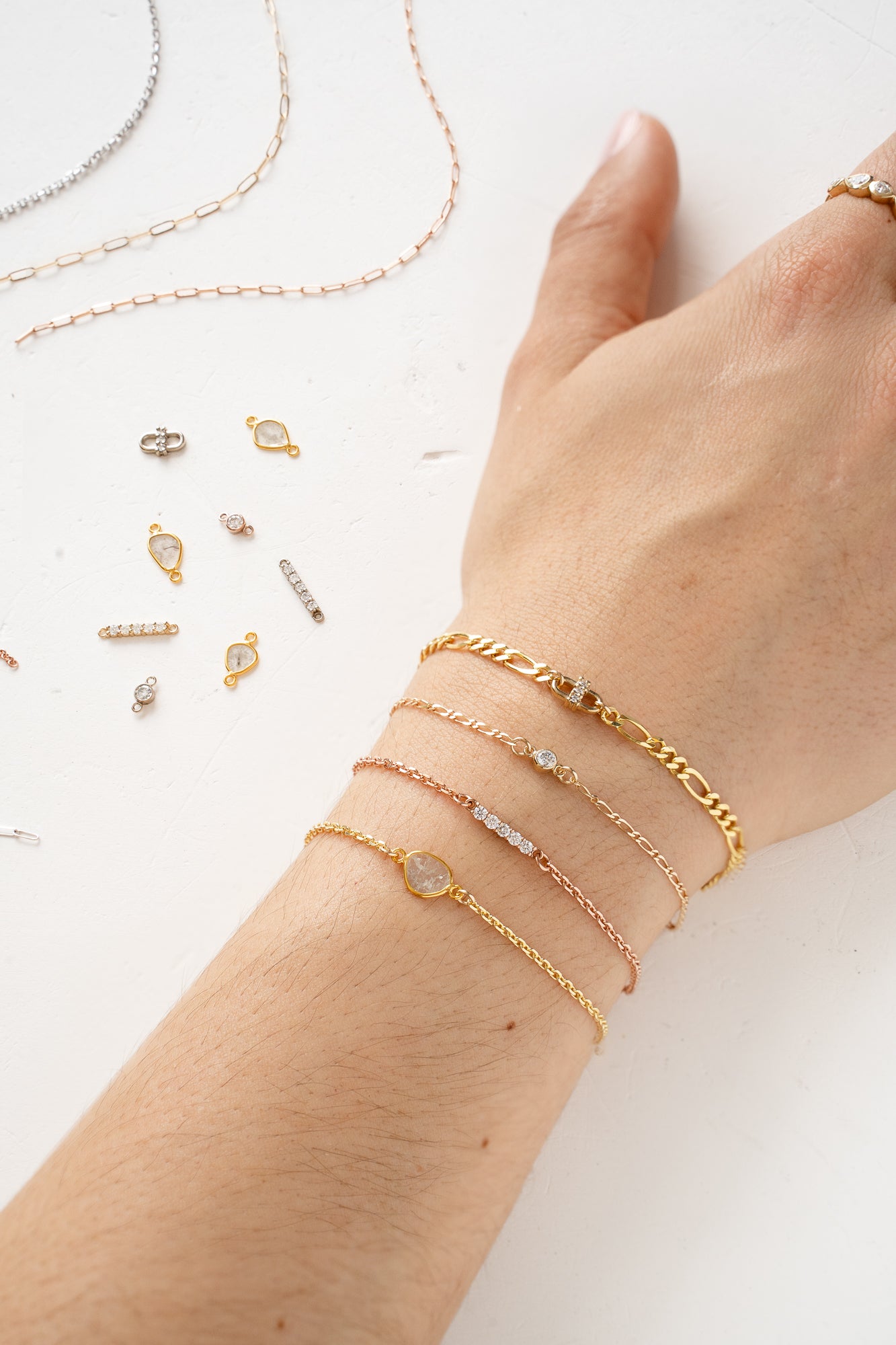 A woman's hand adorned with a bracelet and a delicate gold chain, adding elegance and charm.