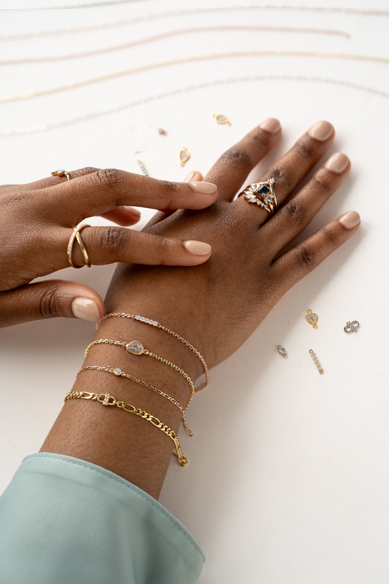 Woman's hands holding stack of gold and silver rings, Forever Linked chains