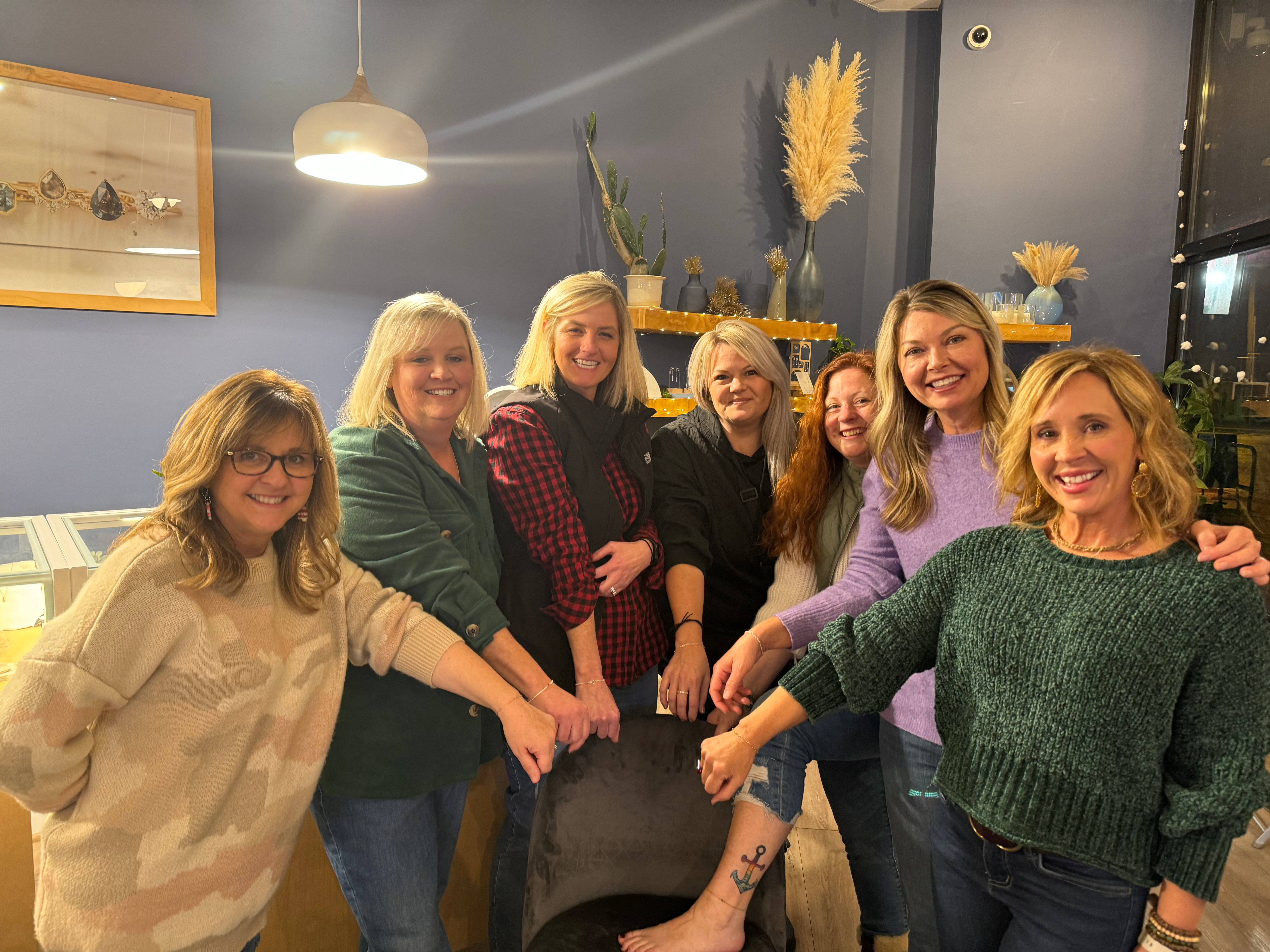 A group of women smiling and posing for a picture at Elaine B Jewelry