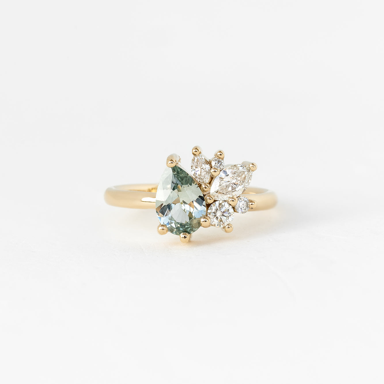 A unique gold ring featuring an aquamarine stone and two diamonds, creating a stunning piece of one-of-a-kind jewelry.