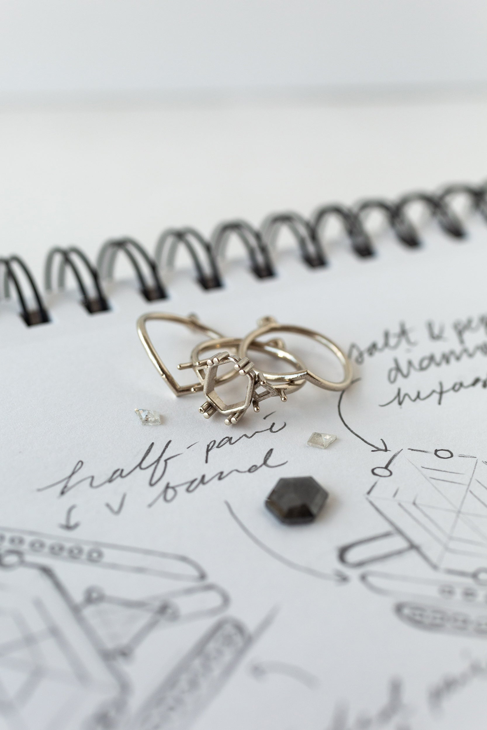 A sketchbook with custom jewelry - a ring and a ring on it.