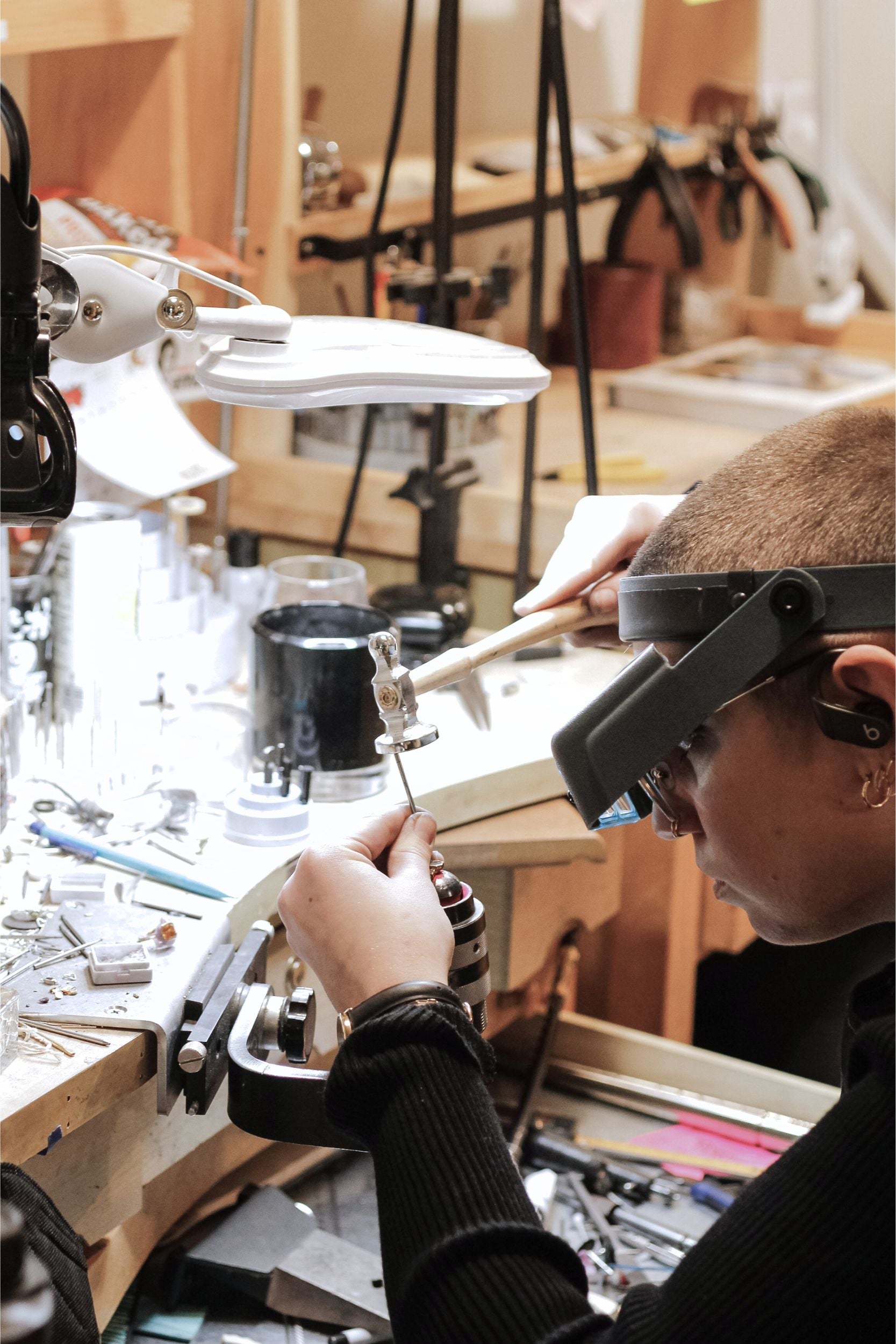 A woman meticulously crafting a custom jewelry project