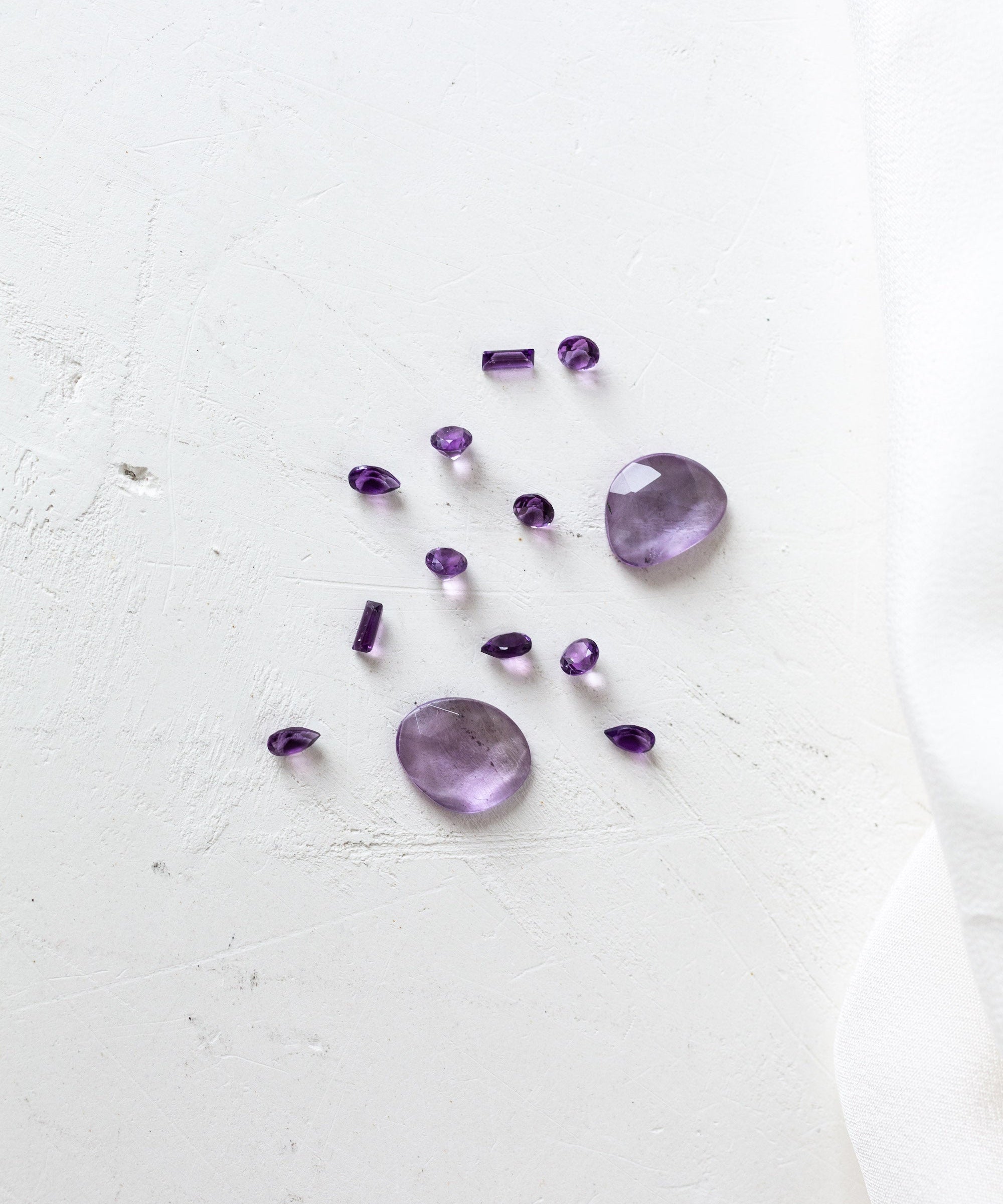 Purple amethyst gemstone on white cloth, perfect for those born in February.