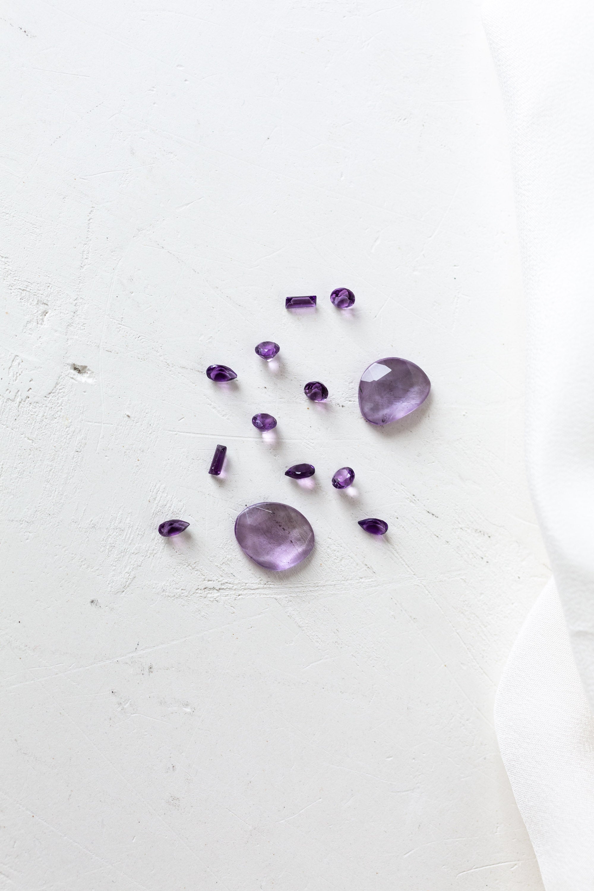 Purple amethyst gemstone on white cloth, perfect for those born in February.