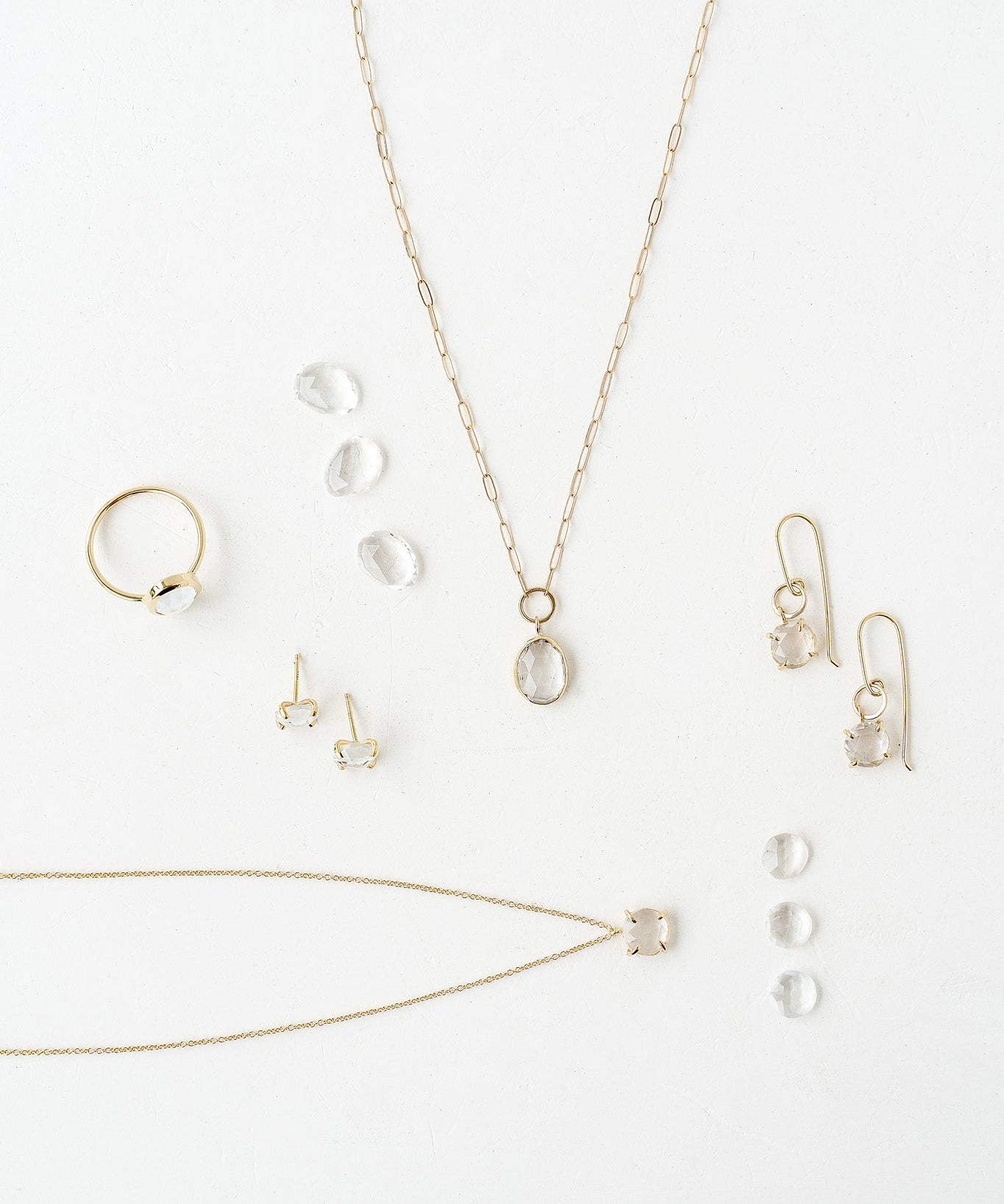 A stunning collection of jewelry featuring a necklace, earrings, and a ring with Diamond and White Topaz birthstones.