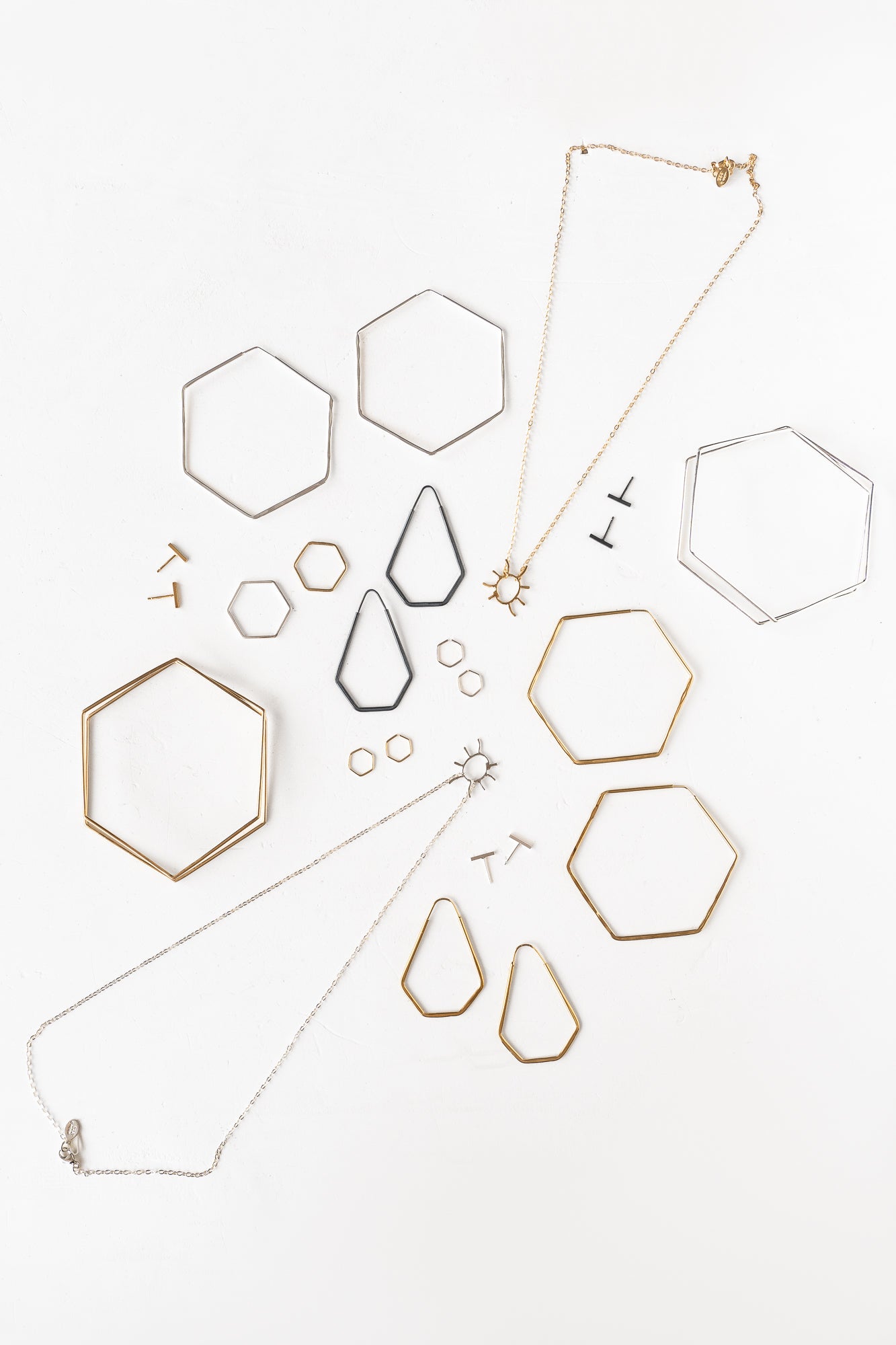  A variety of jewelry pieces including Chemistry collection with faceted hexagons and lines for a minimalist look.