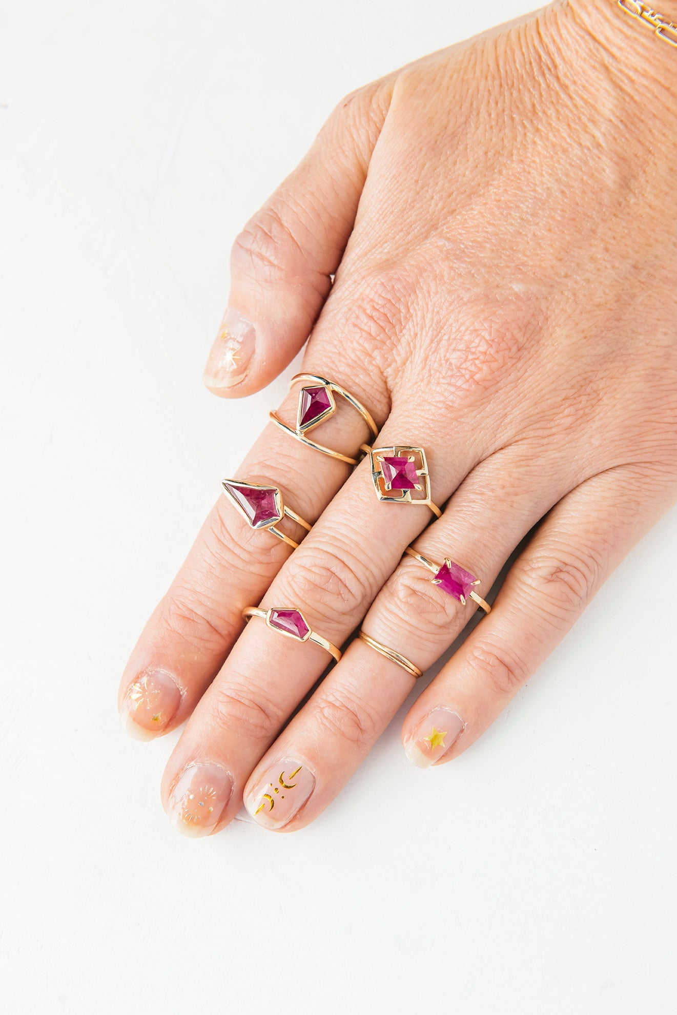 A woman with curly hair wearing a white shirt and earrings, showcasing new arrivals.
