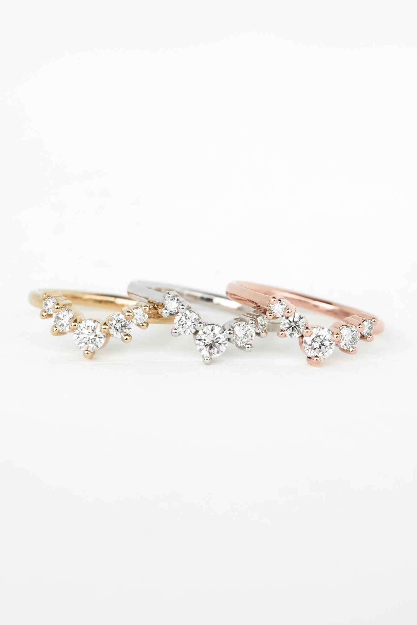 Jewelry and rings from the Constellation Collection, featuring glittering stones held by traditional little dot prongs, on a white surface.