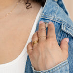 Gold concentric midi ring on neutral background