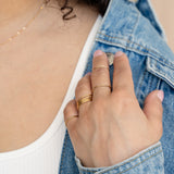 Gold concentric midi ring on neutral background
