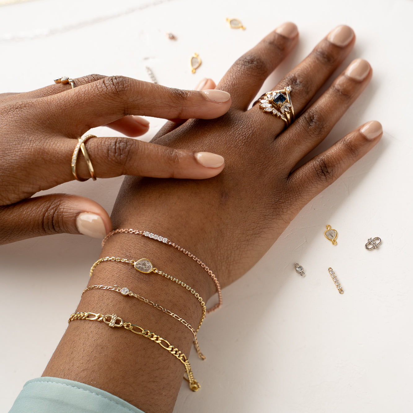 Woman's hands holding stack of gold and silver rings, Forever Linked chains