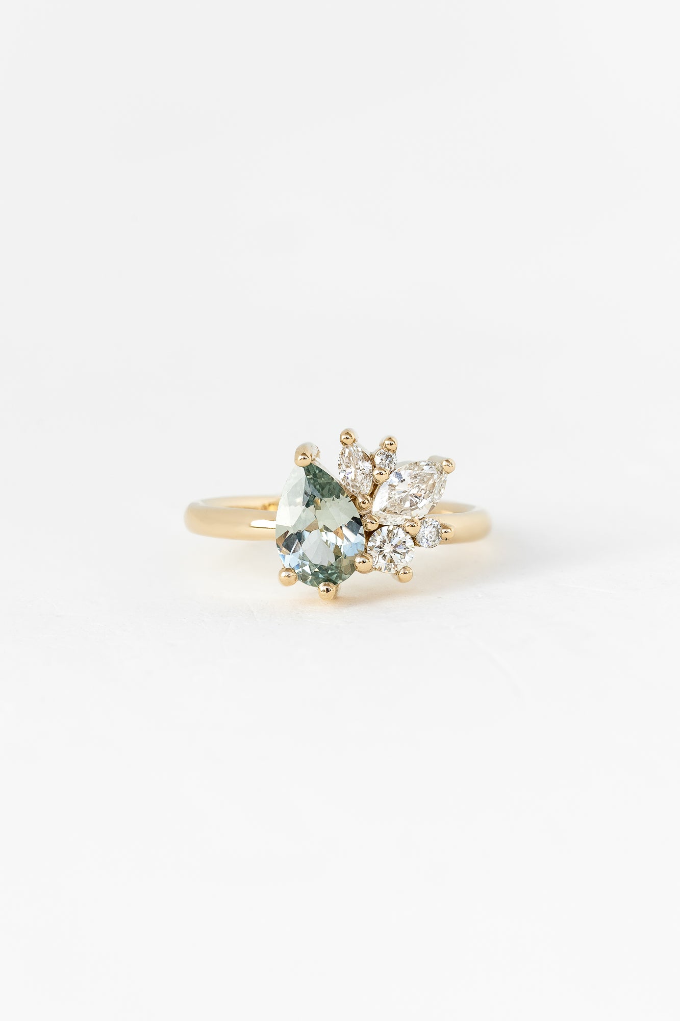 A unique gold ring featuring an aquamarine stone and two diamonds, creating a stunning piece of one-of-a-kind jewelry.