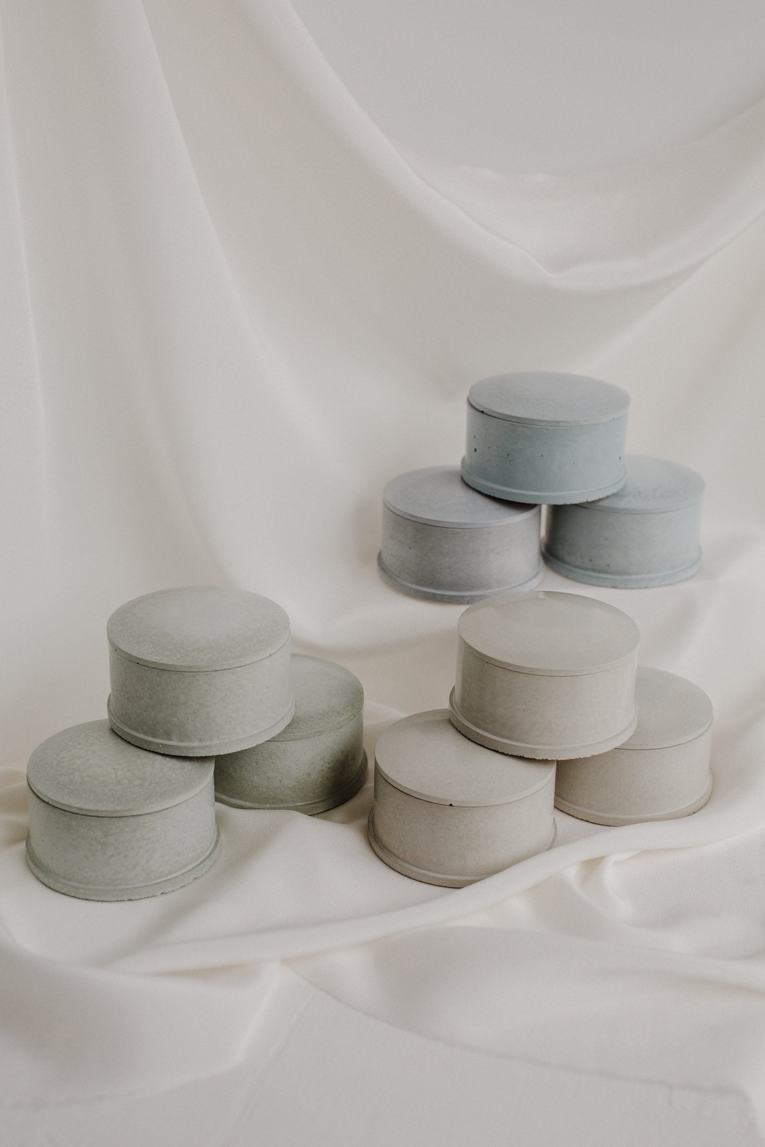Pastel cement jewelry dishes on white background