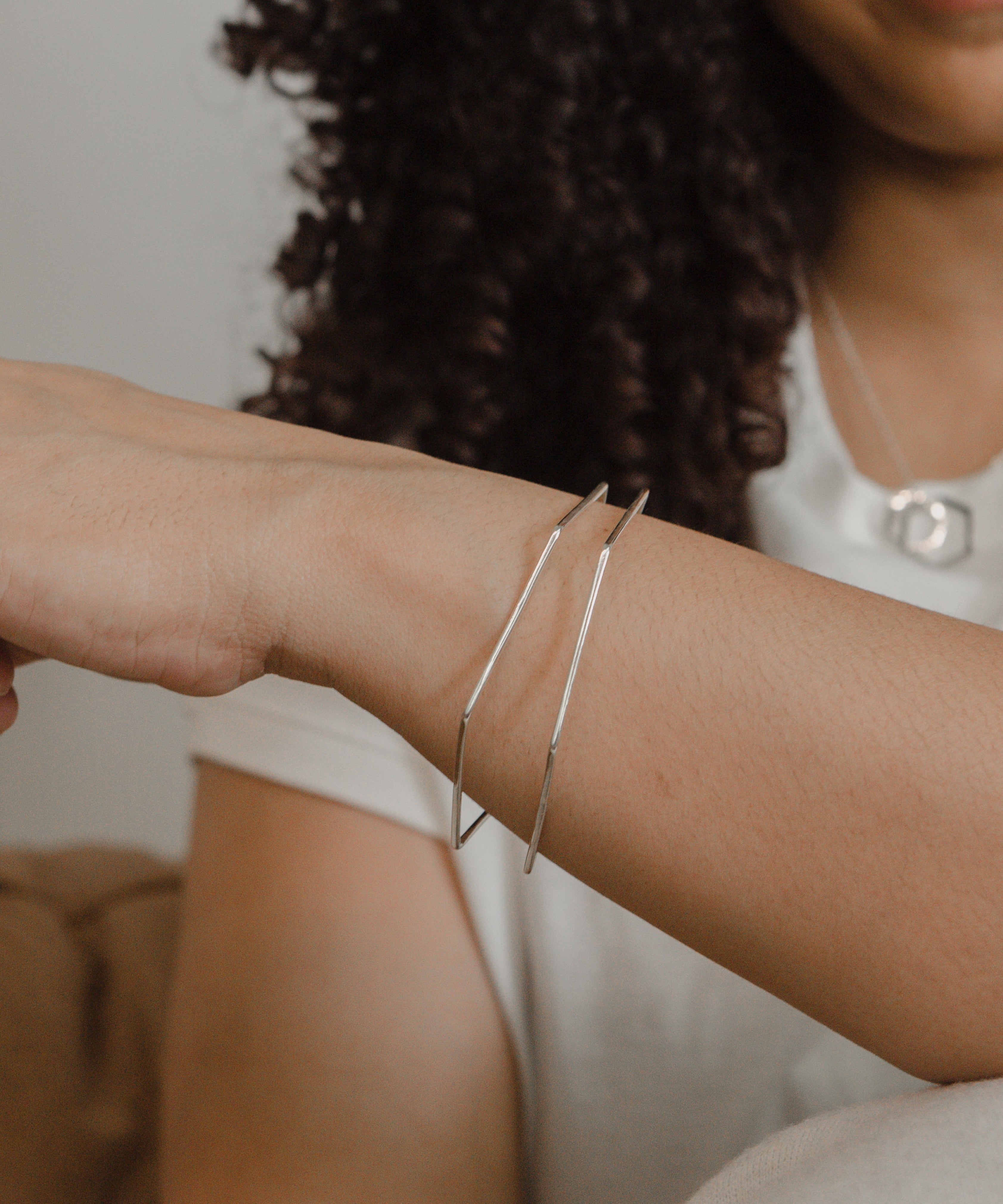 Model showcasing delicate gold jewelry outdoors